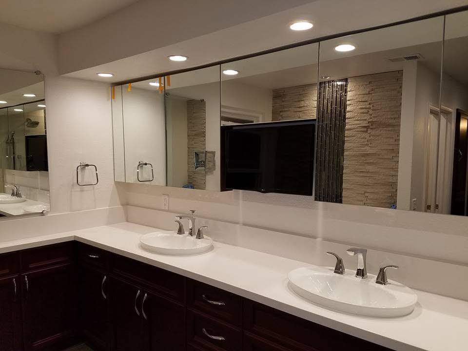 Double vanity with a mirror wall and recessed lighting